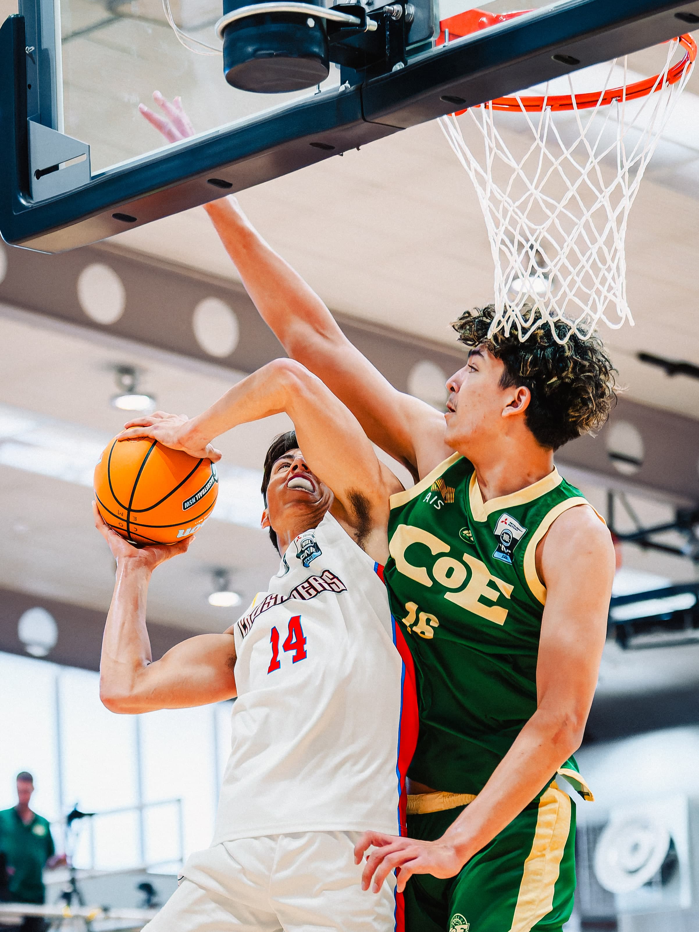 A Central Coast Crusaders guard attacks the ring under the backboard with a Centre of Excellence defender on him