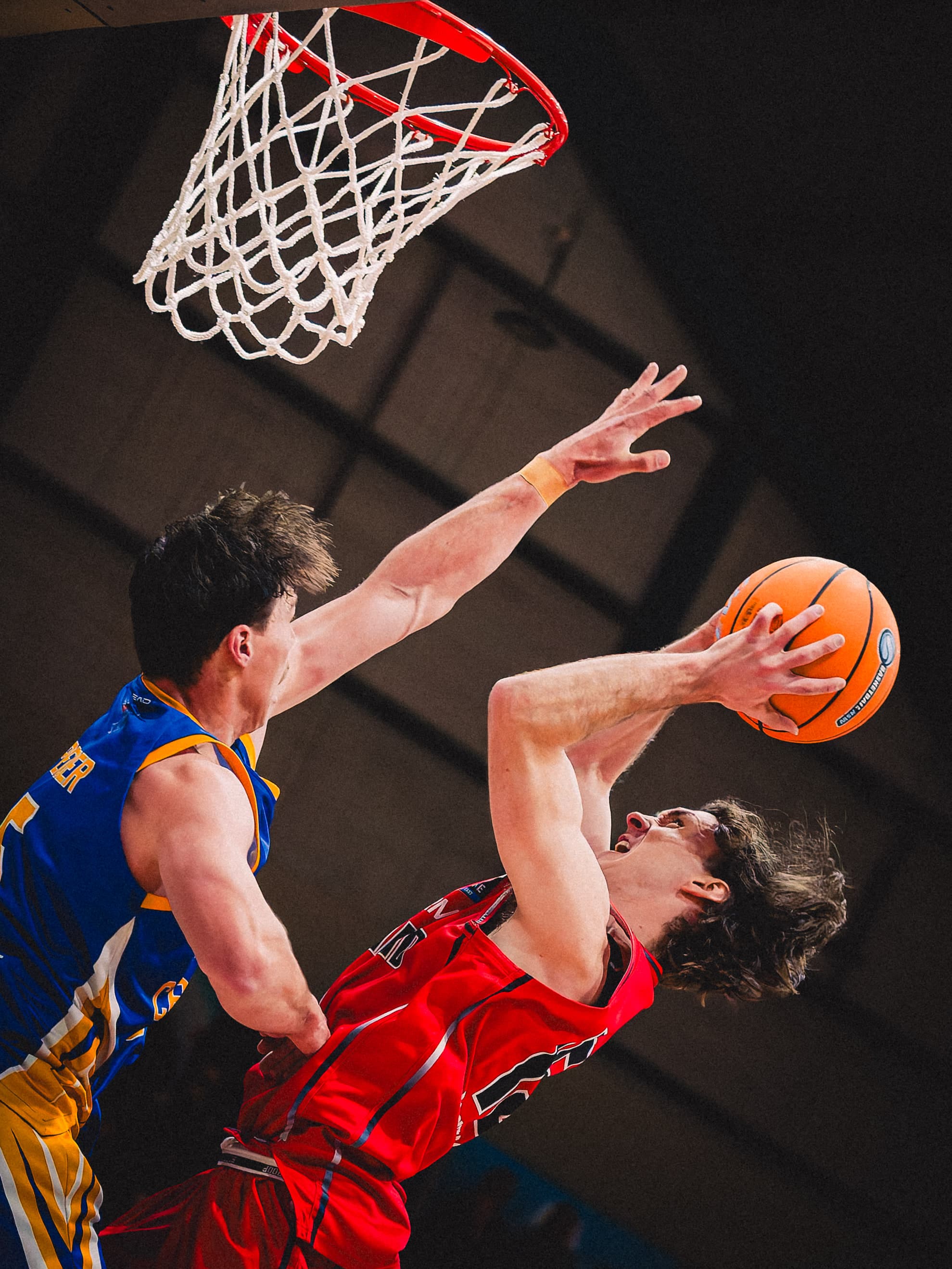 A Maitland Mustangs player bends back under the ring to get a shot away over a Canberra Gunners defender