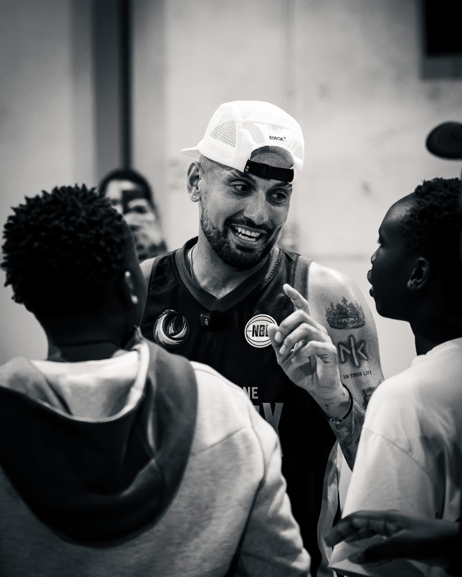 Nick Kyrgios talks with young players between games at Takeover AUS