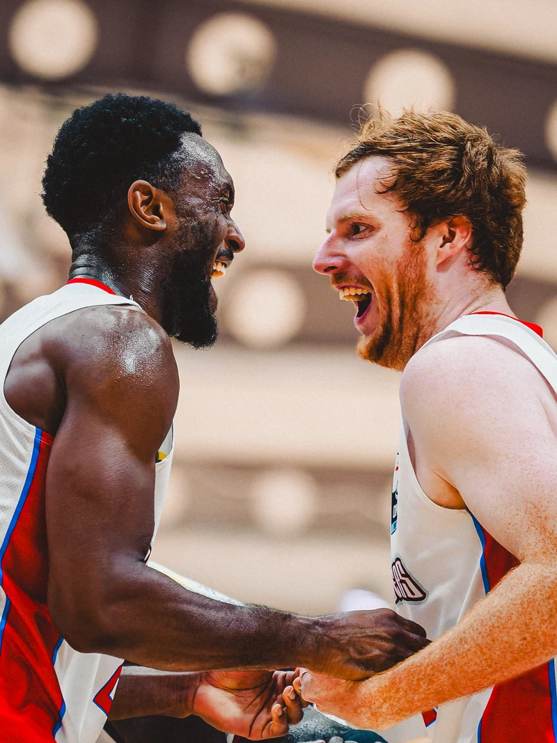 Two basketball players smiling at each other