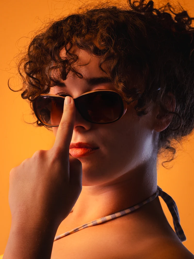 Studio portrait with sunglasses and warm orange light