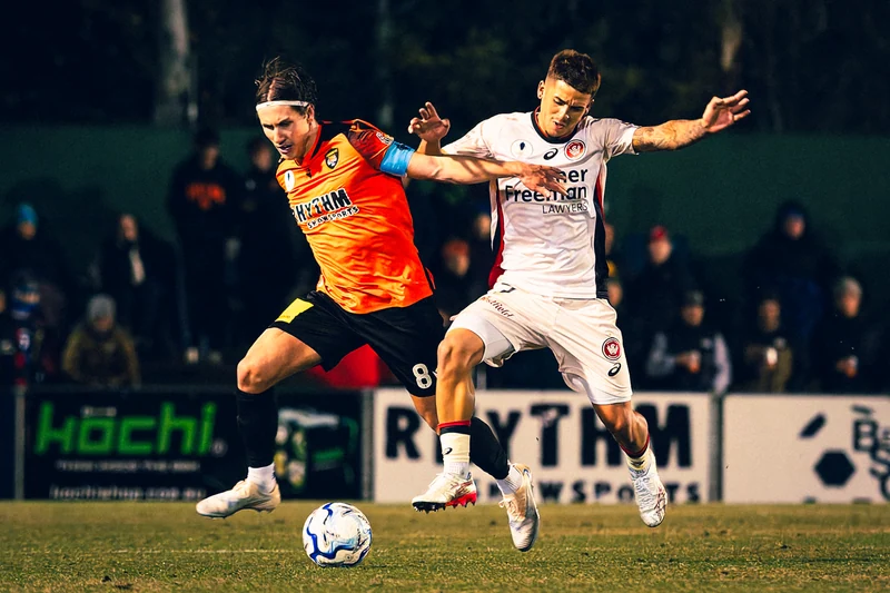 Two football players contesting the ball in mid-stride