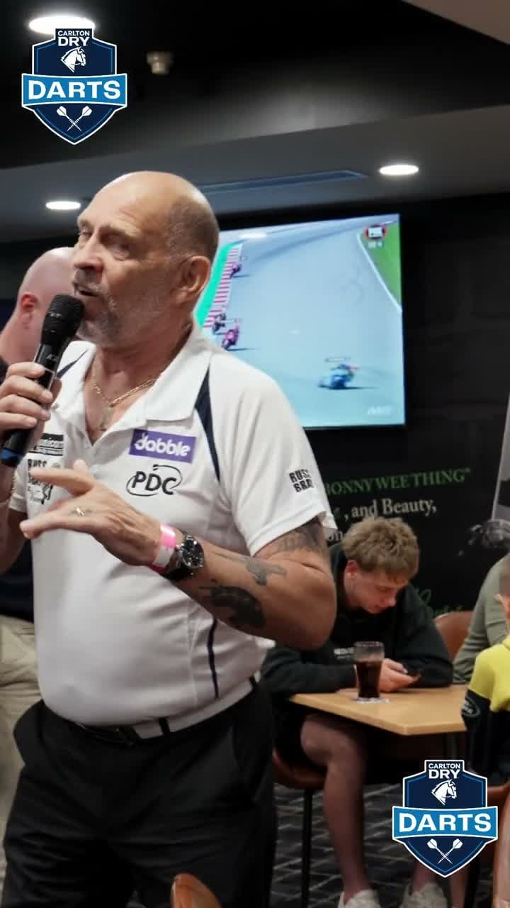 A player holding a microphone at the Carlton Dry darts night