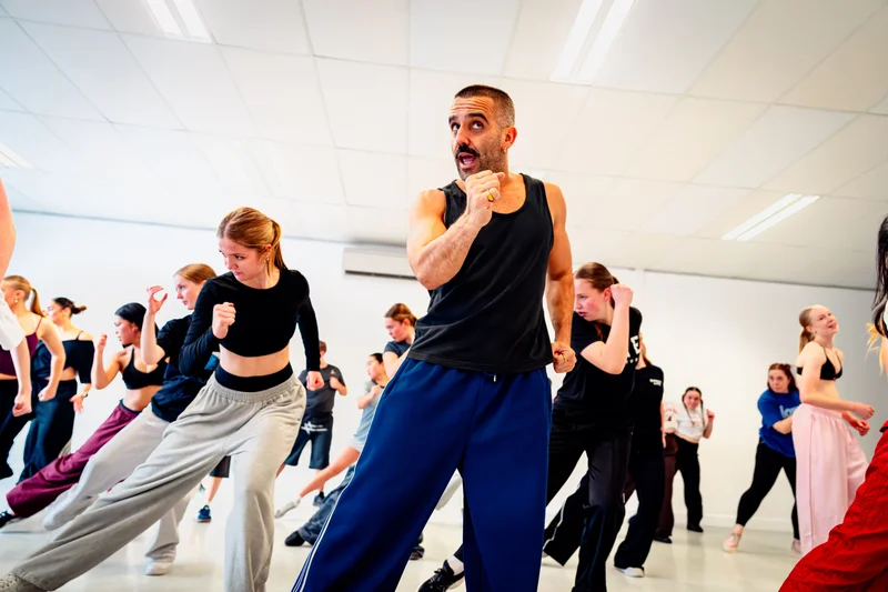 Stephen Tannos demonstrating a dance movement with the class behind him at Elite Dance Studios