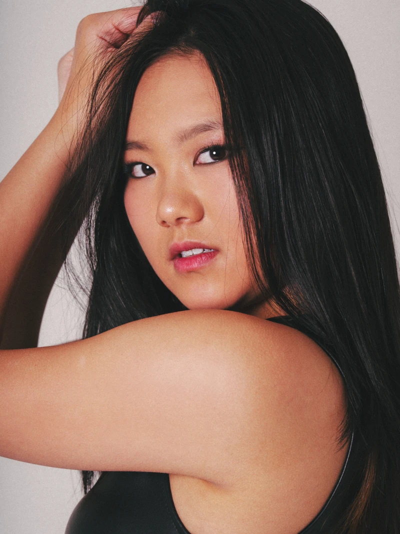Close studio portrait with an arm raised and hair framing the face