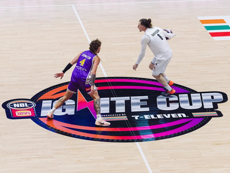 Sydney Kings and New Zealand Breakers players facing each other over the centre-court logo